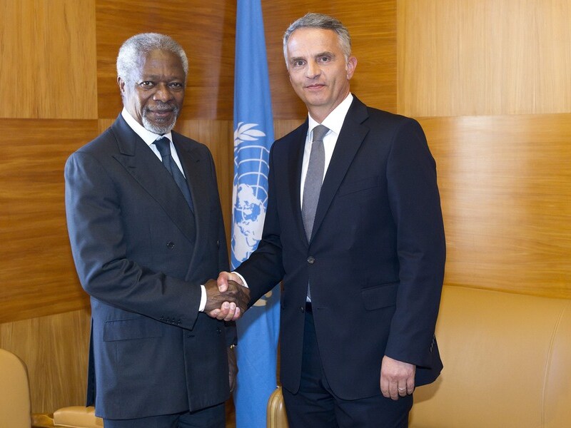 VN-commissaris Kofi Annan schudt handjes met de Zwisterse minister voor Buitenlandse Zaken Didier Burkhalter voor de vergadering in het Europese VN-hoofdkantoor in Genève.