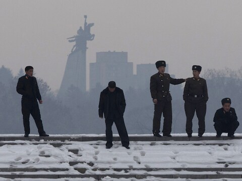 Noord-Koreaanse soldaten aan de oever van de Han rivier, met op de achtergrond het standbeeld van Chollima, een gevleugeld paard in Pyongyang.