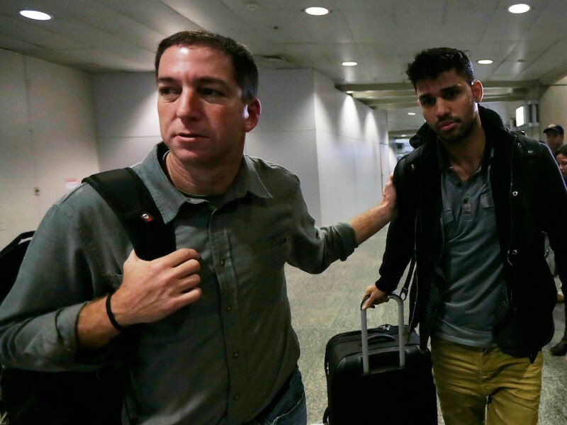 Guardian-journalist Glenn Greenwald (L) loopt met zijn partner David Miranda (R) op het vliegveld van Rio de Janeiro
