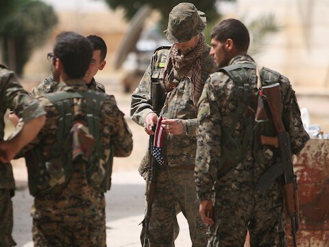 Archieffoto van een Amerikaanse soldaat en Syrische militairen in de noordelijke provincie Raqqa.