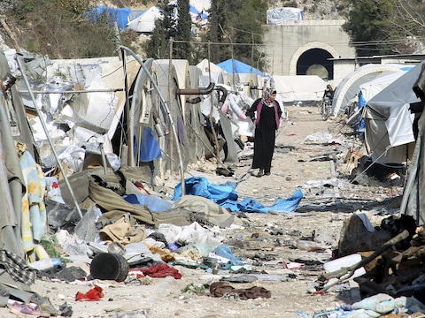 Een vrouw aanschouwt de verwoesting in een intern vluchtelingenkamp dat gisteren (volgens getuigen door Syrische troepen) werd vernield in het Syrisch-Turkse grensgebied in de provincie Latakia, Syrië.