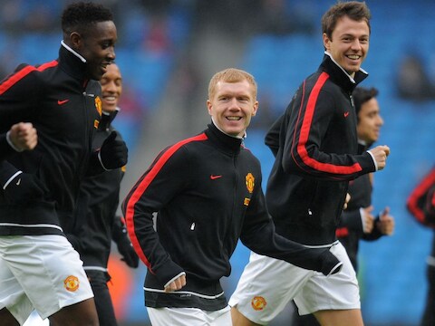 Paul Scholes (C) is bezig aan de opwarming voor de match van vandaag tegen City.
