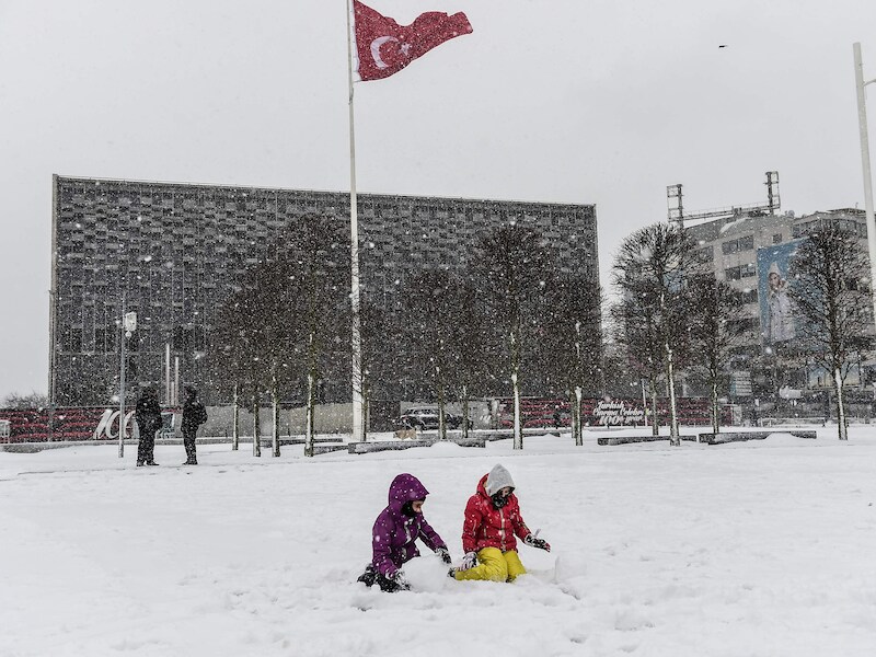 Kinderen spelen in de sneeuw op het bekende Taksimplein in Istanboel.