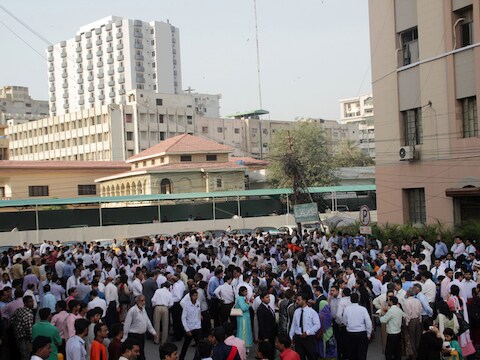 Kantoorwerknemers vluchten massaal de straat op in Pakistan na de aardbeving.