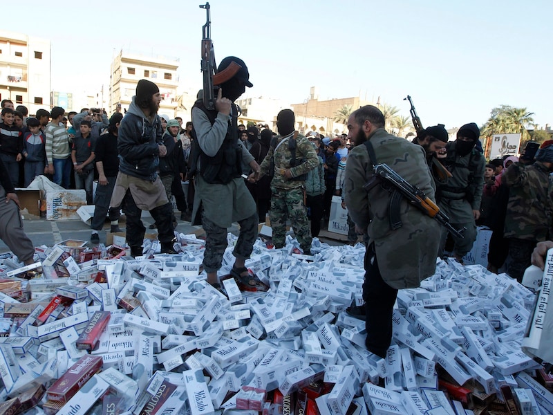 Gewapende IS-strijders vernietigen in beslag genomen pakken sigaretten in Raqqa, het bolwerk van de terreurgroep. (Archieffoto)