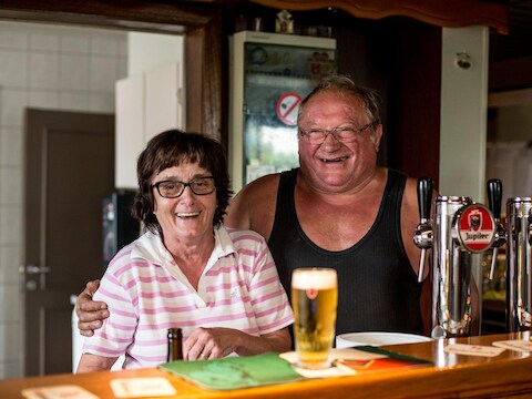 Uitbaters Alfonsine en Marc, deze zomer achter de toog van hun café, De Schorpioen in Kalken.