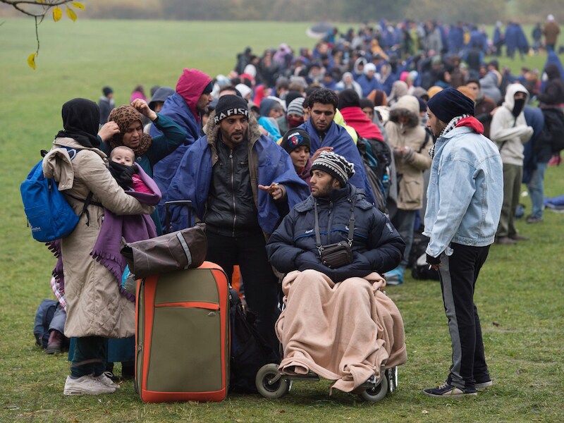 Vluchtelingen wachten aan de grens met Oostenrijk om naar Duitsland te trekken.