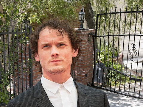 Acteur Anton Yelchin. Achter hem het gedeukte hek bij zijn woning in Los Angeles.