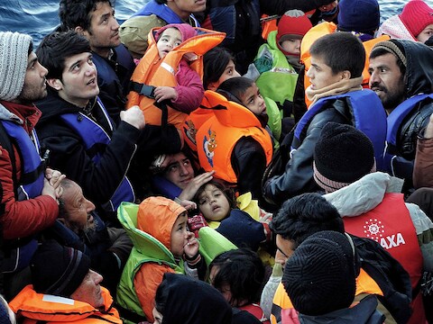 Vluchtelingen zitten samengepakt op een bootje dat in de buurt van Lesbos door de Griekse kustwacht wordt opgemerkt.