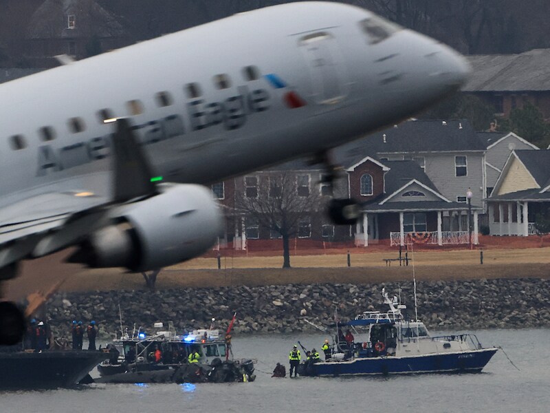 Een vliegtuig stijgt op terwijl bergingsploegen werken bij het wrak van de neergestorte helikopter in de Potomac-rivier bij Washington. (31/01/25)