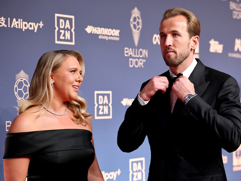 Katie Goodland kijkt toe hoe haar man Harry Kane zijn strikje nog eventjes op zijn plaats trekt.