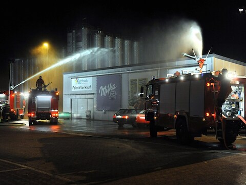 Brandweerlui proberen de gifwolk met water onder controle te krijgen.