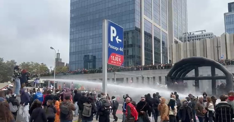 De politie zet het waterkanon in tegen betogers aan de Financiëntoren in Brussel tijdens de nationale betoging.