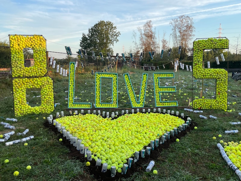Vrienden van Brecht en Sandy dumpten 11.000 padel- en tennisballen op hun bouwgrond, en maakten er dit kunstwerkje mee.