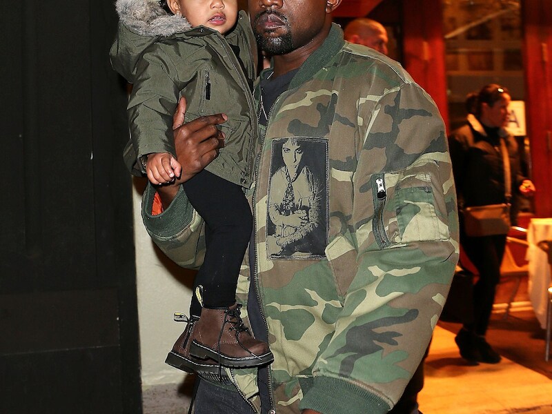 Kanye West met dochtertje North op de arm.
