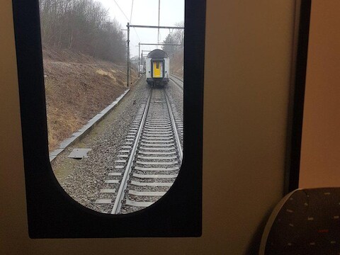 Twee treinwagons zijn losgekomen van de rest van de trein en staan stil op de sporen.