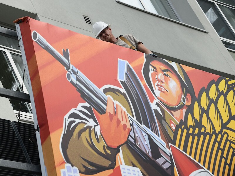 Een arbeider verwijdert een poster van 'The Interview' in Hollywood.