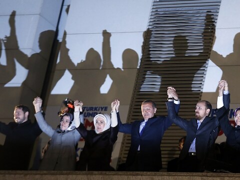 Premier Erdogan en familieleden op het balkon van het partijkantoor in Ankara, zondagavond. Een menigte juicht hen toe.