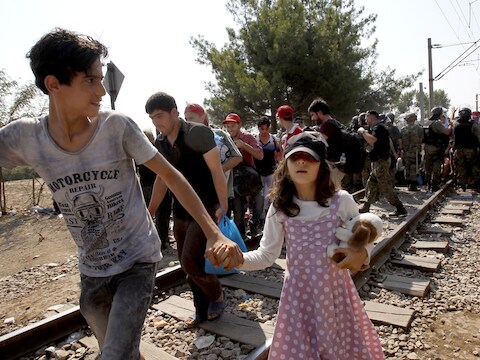 Een politiekorps uit Macedonië voorkomt dat migranten met tientallen tegelijk over de grens stormen. Ze verlenen voorrang aan families met kinderen.