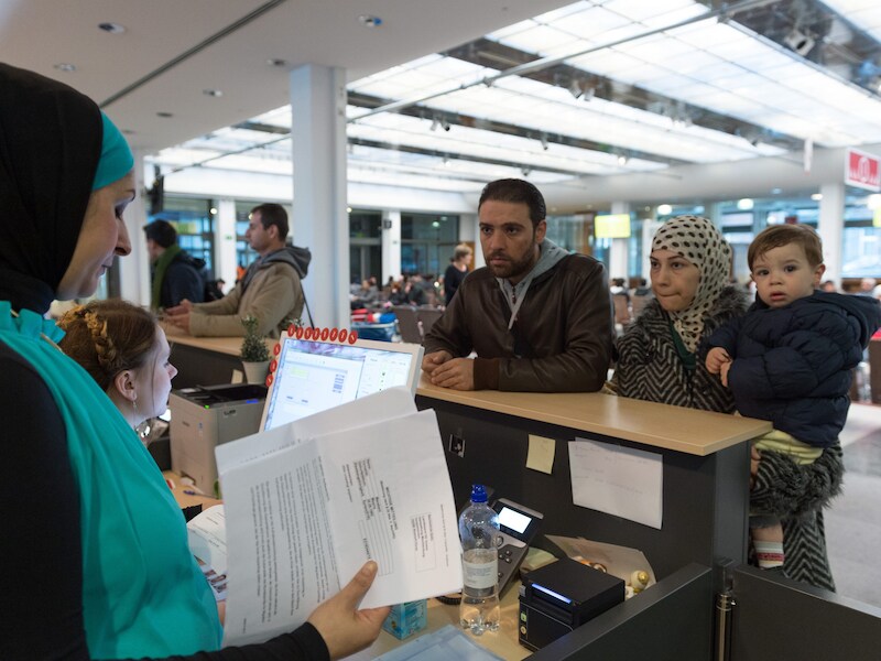 Syrische vluchtelingen spreken met een tolk tijdens hun registratieproces in Duitsland.
