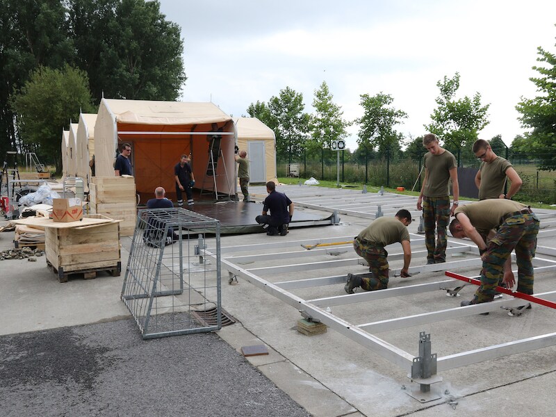 Militairen trekken de mobiele wooneenheden op naast het asielcentrum.