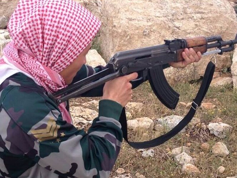 Een buitenlandse strijder, naar eigen zeggen afkomstig uit Denemarken, poseert voor een foto in een trainingskamp van het rebellenleger tussen Idlib en Aleppo, vorig jaar mei.