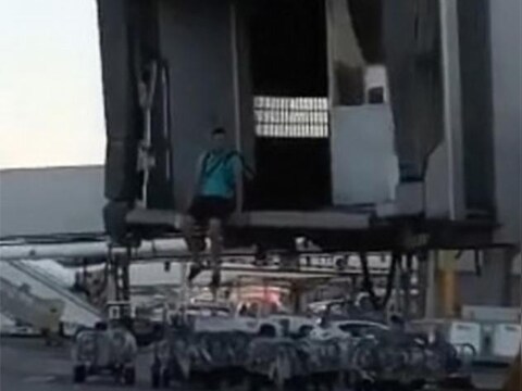 De passagier aarzelt nog even voor hij van de passagiersbrug springt.