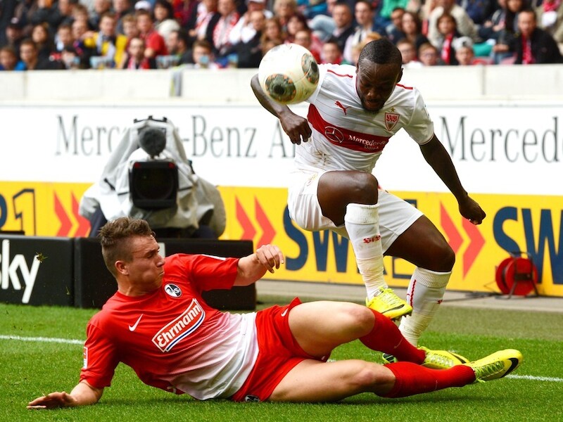 Arthur Boka probeert een tackle van Felix Klaus (Freiburg) te ontwijken.