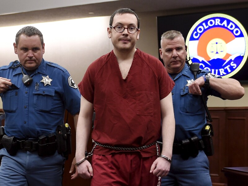 James Holmes wordt weggeleid.