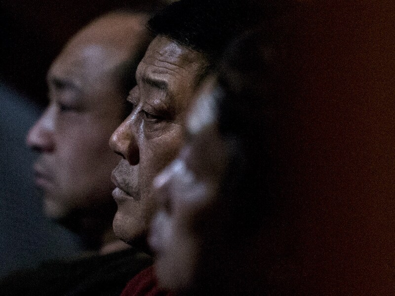 Verwanten van inzittenden van vlucht MH370 kijken in een hotel in Peking naar een nieuwsuitzending.