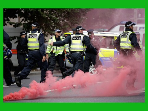 Politieagenten zaterdag tijdens de rellen in Londen.