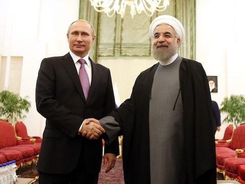 Russisch president Vladimir Poetin schudt Iraans president Hassan Rouhani de hand tijdens een top van gasexporterende landen in november vorig jaar.