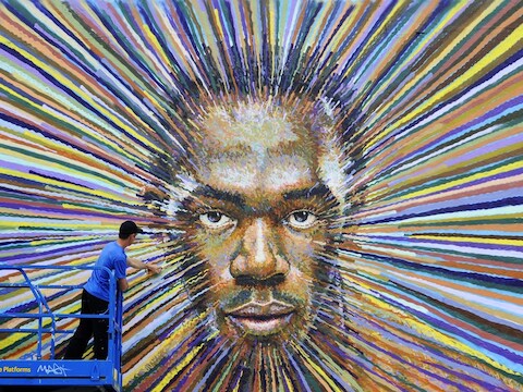 Graffiti-artiest James Cochran legt de laatste hand aan de beeltenis van het gezicht van Usain Bolt.