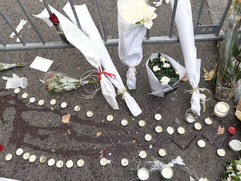Kaarsen en bloemen aan bloedsporen aan concertzaal Bataclan.