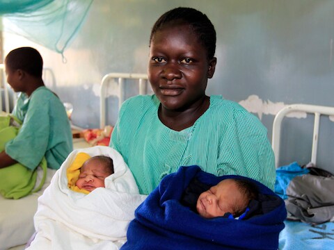 Een trotse Millicent Owuor, met links Barack Obama en rechts Mitt Romney
