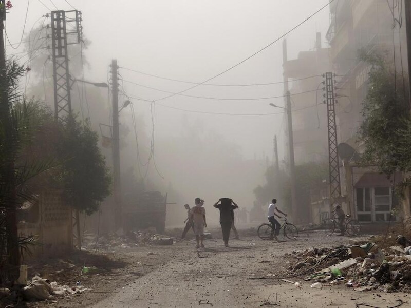 Bewoners van Deir Al-Zor inspecteren de schade na wat een aanval van Syrische troepen zou zijn geweest.