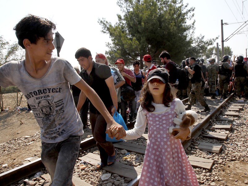 Een politiekorps uit Macedonië voorkomt dat migranten met tientallen tegelijk over de grens stormen. Ze verlenen voorrang aan families met kinderen.