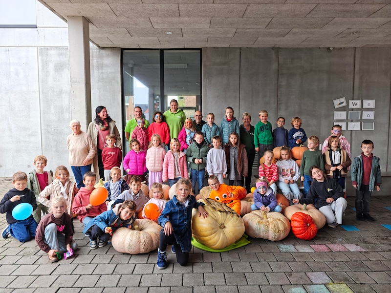 De kindjes met hun pompoenen. Amber van VBS De Bosbes won de wedstrijd met de grote, gele pompoen waarop ze leunt.