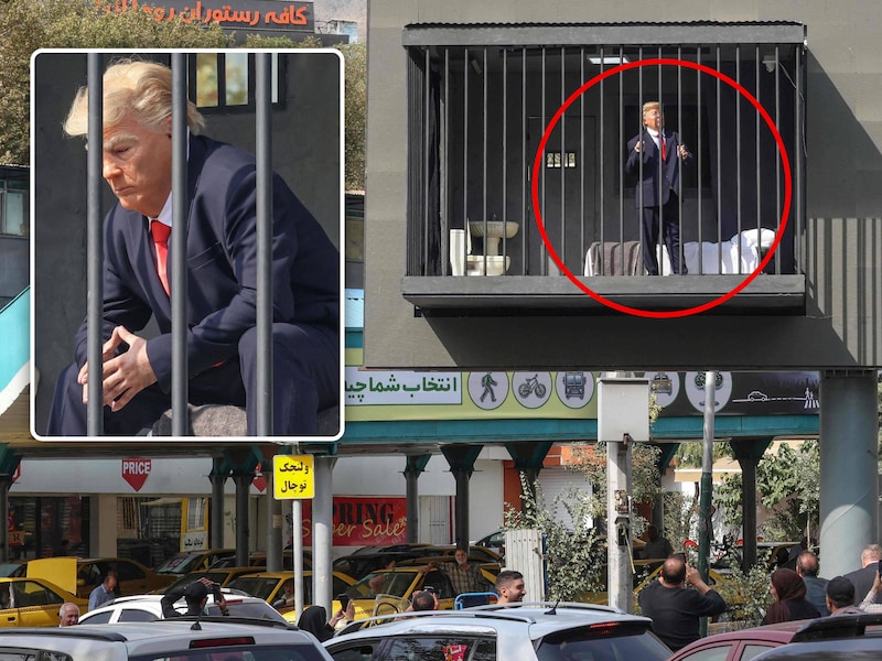 De opvallende installatie in Teheran, met een valse Trump in een klein celletje boven de weg.