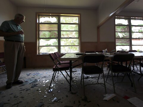 Een man overziet de schade die de explosie in een kunstmestfabriek aanrichtte in de Brethren Church in West (Texas).
