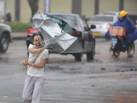 Een Chinese vecht tegen de wind in Qionghai.