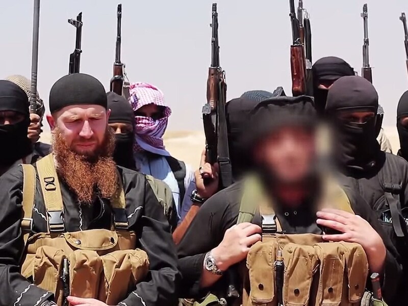 Abu Omar al-Shishani, met rode baard, tussen andere extremisten van IS.