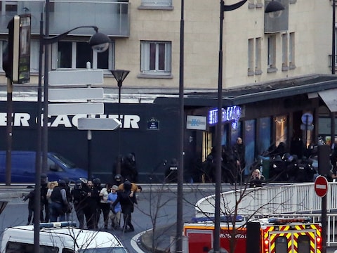Gijzelaars worden na de bestorming door de politie in veiligheid gebracht.