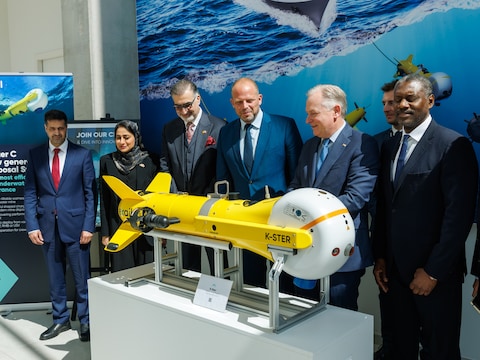Minister Theo Francken (N-VA) en Steven Luys, CEO van Exail Belgium, geflankeerd door vertegenwoordigers van de Golfstaten. Op de voorgrond: de K-STER van Exail, een onderwaterdrone die gebruikt wordt om mijnen onschadelijk te maken. 