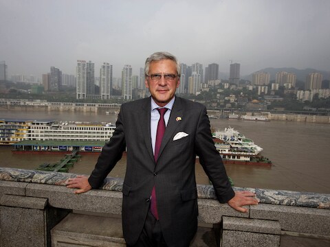Kris Peeters poseert voor de skyline van Chongqing.