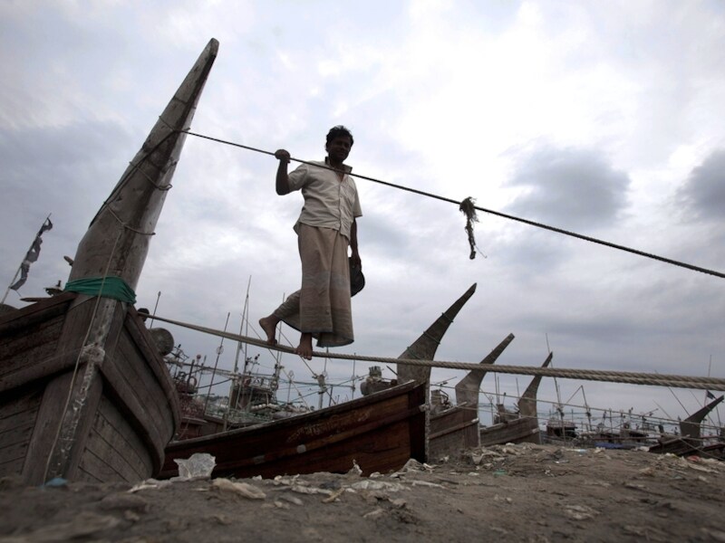 Een visser in Bangladesh maakt zijn vissersboot vast aan de oever van Kornofuli in Chittagong, Bangladesh