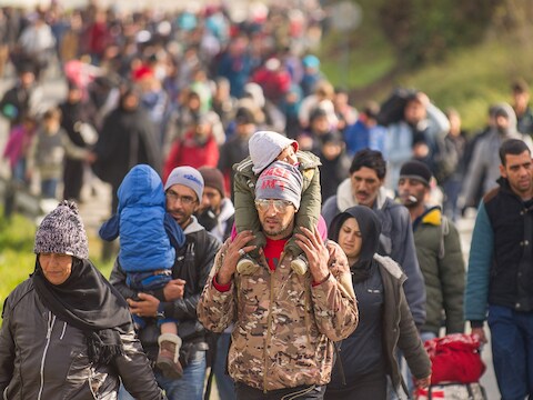 Soldaten begeleiden vluchtelingen op een weg bij Sentilj, Slovenië om de grens over te steken.
