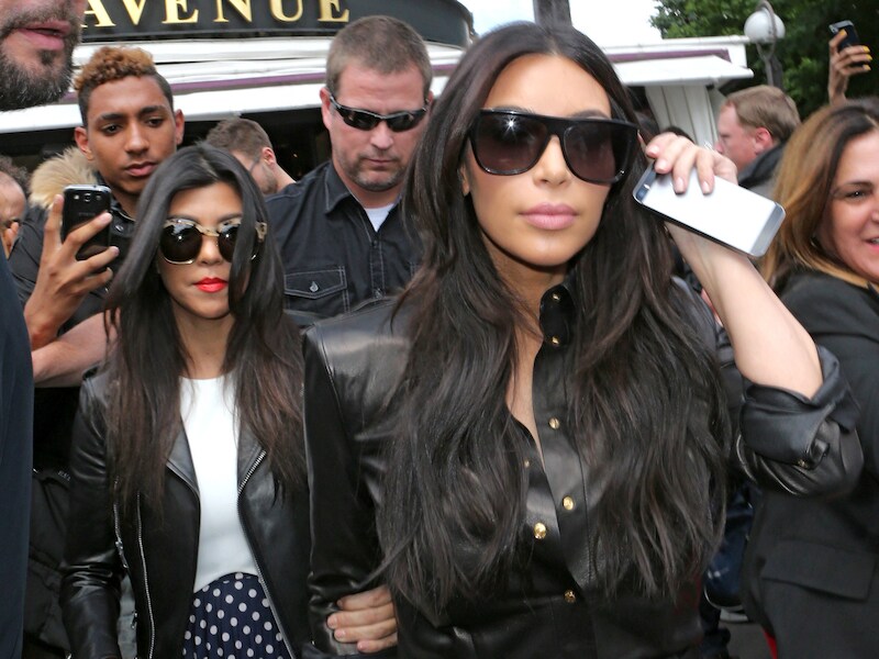 Kim (rechts) en Kourtney Kardashian verlaten het restaurant in Parijs waar het bruiloftsdiner zal worden geserveerd.