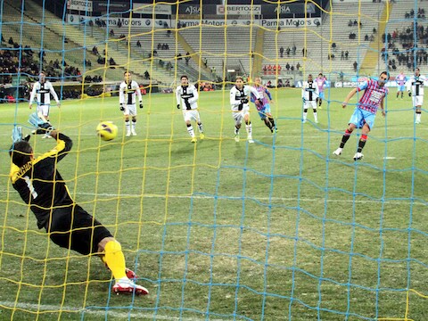 Catania-speler Lodi vloert Parma-goalie Pavarini.