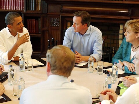 De Amerikaanse president Obama en de Duitse bondskanselier Merkel, gescheiden door de Britse premier Cameron, maandag tijdens de G8 in Enniskillen.